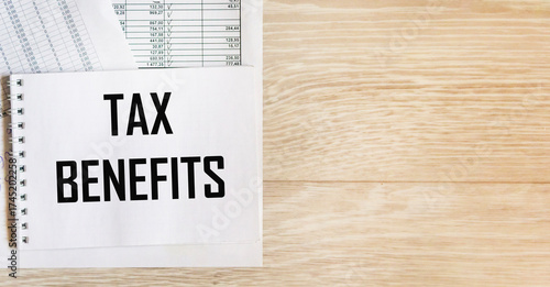 There is an inscription on the notebook TAX BENEFITS against the background of accounting.