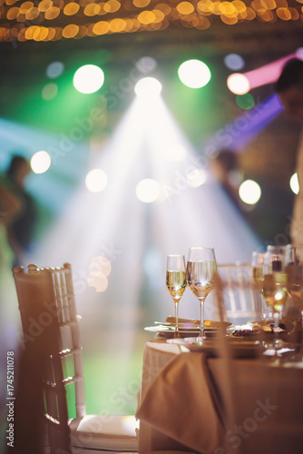 Elegant celebration with vibrant lights and sparkling drinks at a beautifully set table in a lively event space during an evening gathering