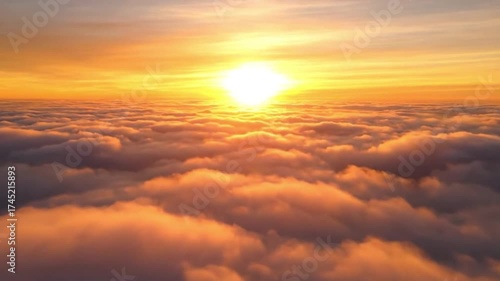 Breathtaking aerial view of a vibrant golden sunrise or sunset over a vast expanse of soft, fluffy clouds, creating a serene and majestic cloudscape.
