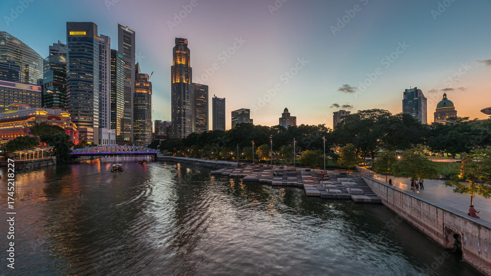 Fototapeta premium Singapore skyscrapers skyline with white Anderson Bridge near esplanade park day to night timelapse.