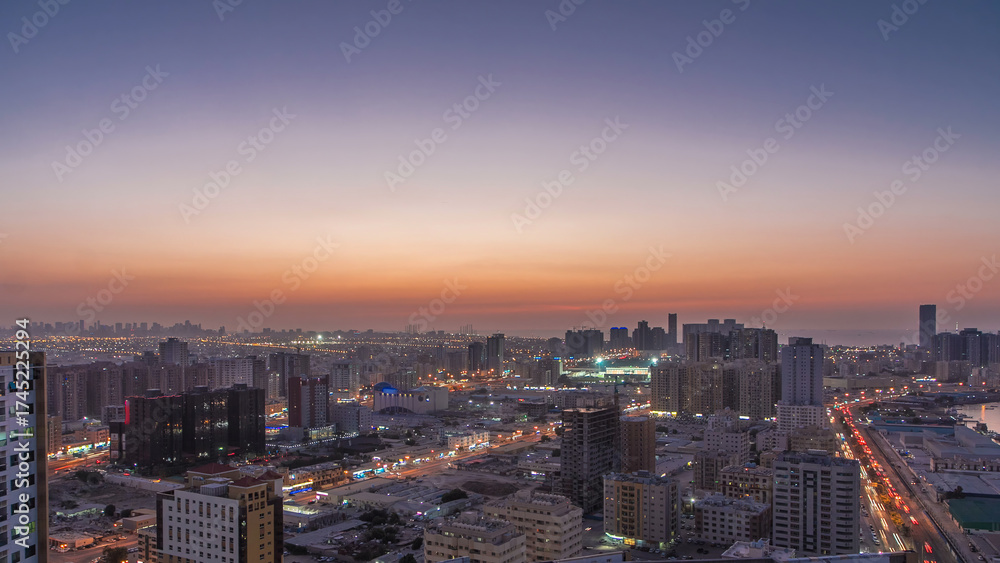 Fototapeta premium Cityscape of Ajman from rooftop day to night timelapse after sunset.