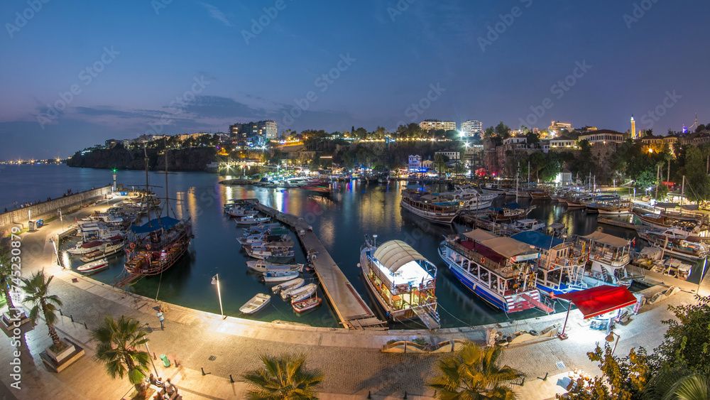 Fototapeta premium Aerial view of yacht harbor and red house roofs in Old town day to night timelapse Antalya, Turkey.