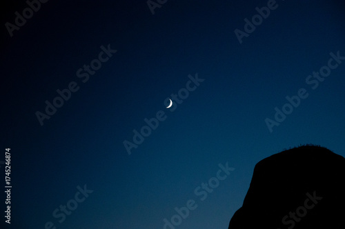 Crescent moon glowing in vibrant night sky