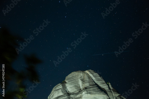 Starlit marble mountain landscape featuring a comet in sky