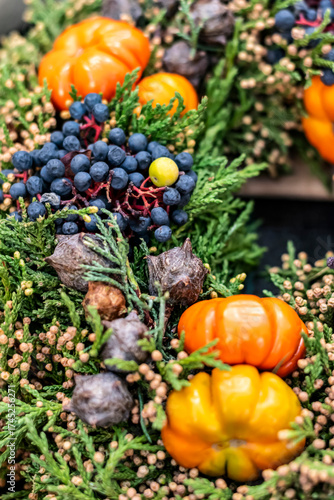 Rustic autumn bouquet with baby pumpkins, juniper, conifers and black chokeberries, selective focus