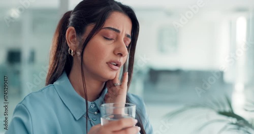 Woman, toothache and stress for pain in office with glass, water and massage for relief at media agency. Person, writer and frustrated with dental crisis, cavity or rotten teeth at creative workplace