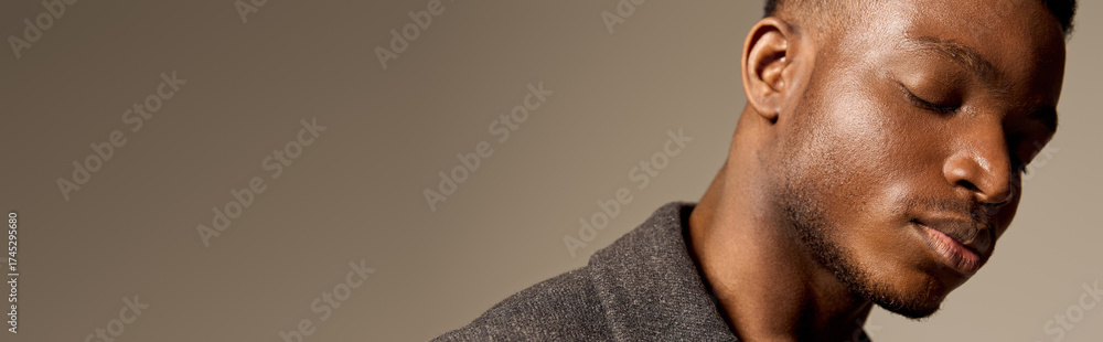 Obraz premium Stylish African American man showcases autumn fashion in a studio setting