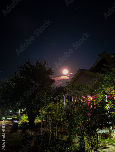 Full moon above peaceful rural night house
