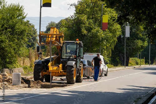 Workers & heavy machinery replace city water pipes. Urban infrastructure repair & development.