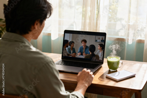 Young remote employee attending virtual mental health support meeting on laptop with cup of matcha latte, cozy work from home and emotional balance