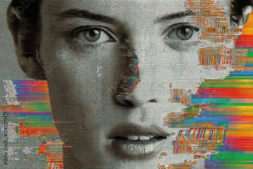 Close up of a woman's face obscured by digital video screen static and bright colorful horizontal glitch effects.