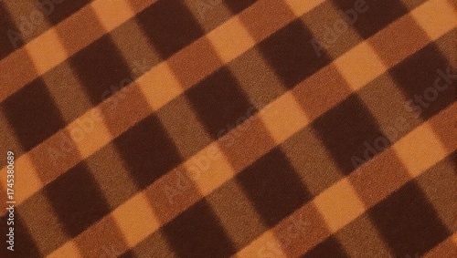 A close-up of a brown and orange plaid pattern on a textured surface