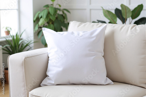 Clean white throw pillow mockup on a comfortable sofa in a cozy living room with plants for a minimalist home decor concept