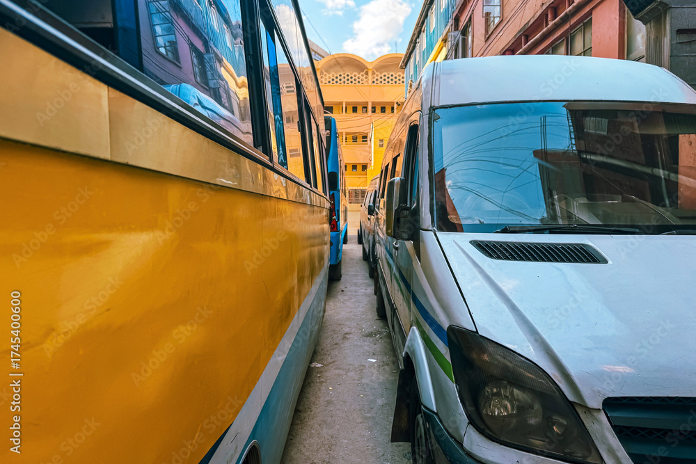 Fototapeta premium View of a narrow space between public transport vehicles stuck on a traffic jam on a street in Nairobi City, Kenya 
