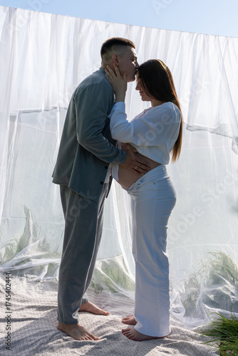 Canvastavla Maternity love in the sunlight. Embracing family expecting a baby