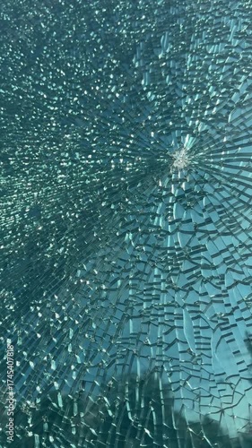 a broken window with a bullet or stone mark. The broken window has not crumbled into pieces and holds its shape.