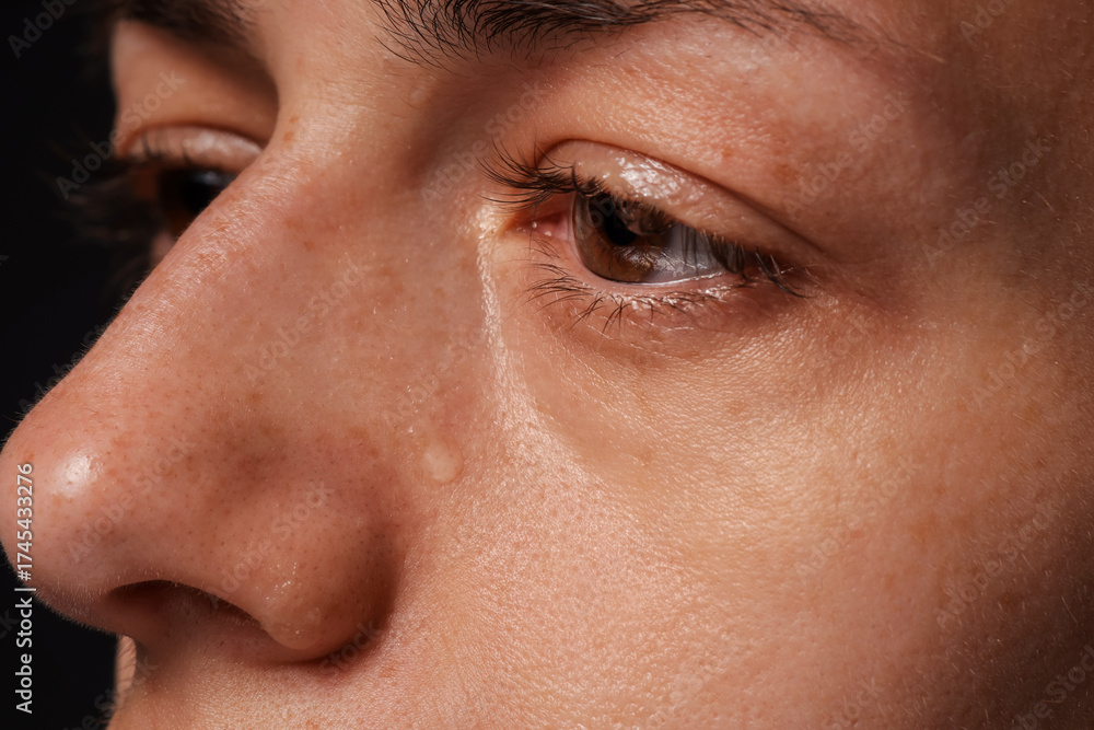 Fototapeta premium Sad woman crying on black background, closeup