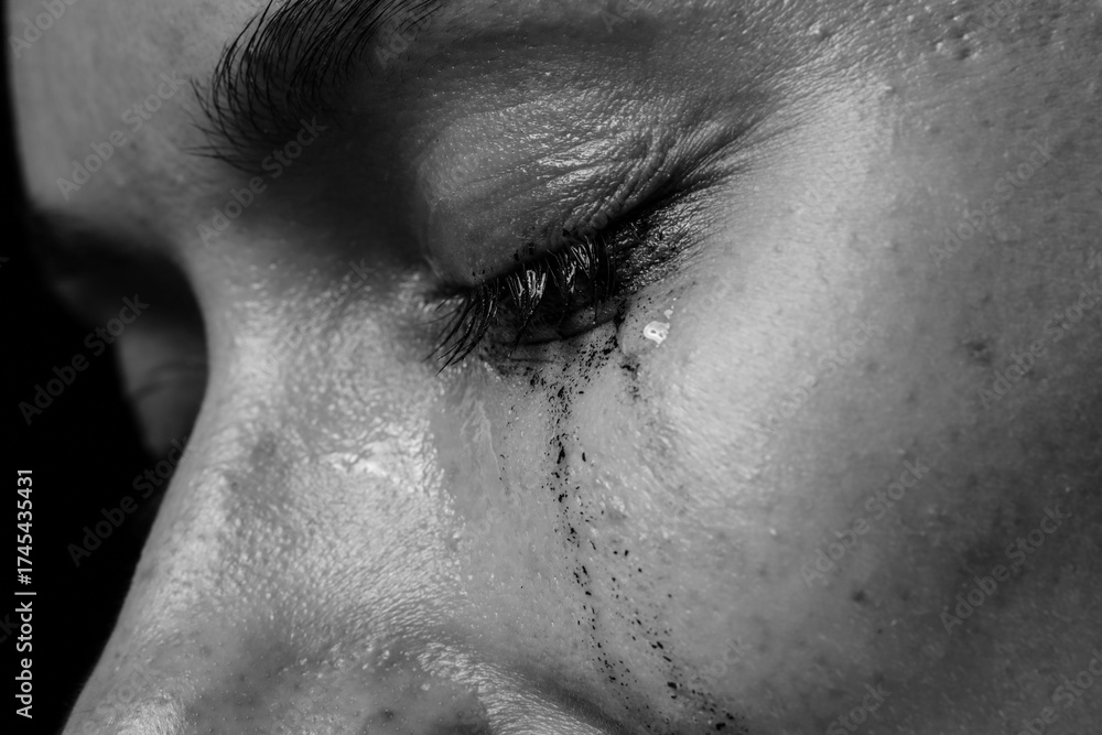 Fototapeta premium Sad woman crying on dark background, closeup. Black and white effect