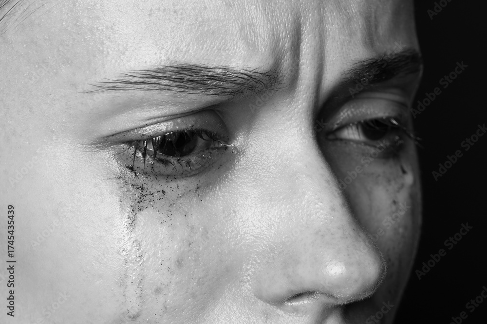 Naklejka premium Sad woman crying on dark background, closeup. Black and white effect