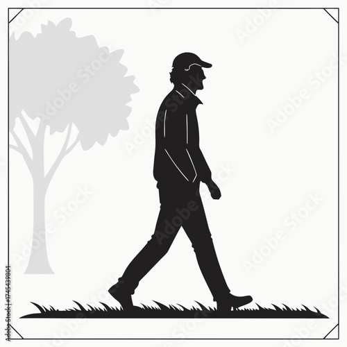 Silhouette of a man wearing a baseball cap and jacket walking outdoors next to a tree