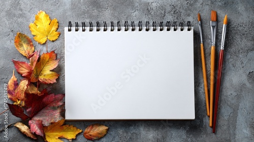 Wallpaper Mural blank white sketchbook notebook with paint brushes and autumn leaves on gray concrete Torontodigital.ca