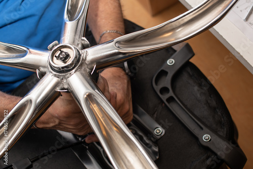 Detalle manos armando base de silla con ruedas de escritorio