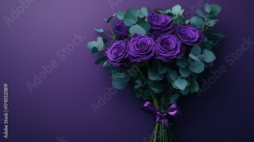 Deep purple roses and eucalyptus bouquet on a purple background