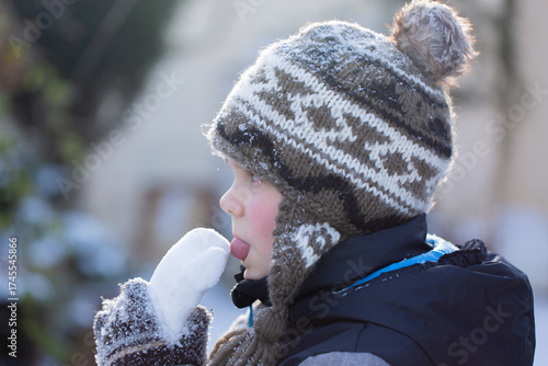 Boy tasting snow heart on sunny winter day symbol of innocence and pure love horizontal