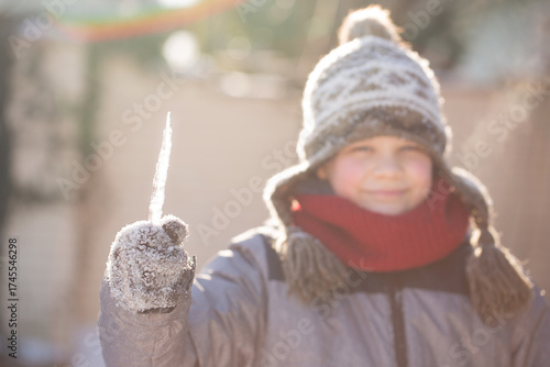Boy smiling with icicle winter sunlight joy and simplicity horizontal