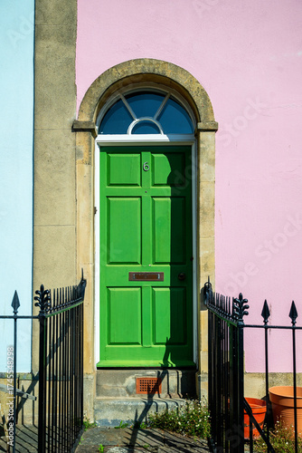 Fotografie Vibrant green door on pink stone house.