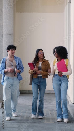 Group of multiethnic university students walking and talking together in a hallway on campus