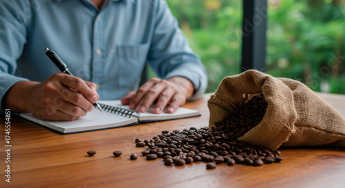 Coffee business owner taking notes while evaluating roasted specialty coffee beans.