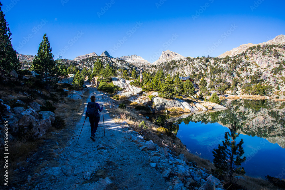 Fototapeta premium Young hiker woman in autumn in Aiguestortes and Sant Maurici National Park, Spain