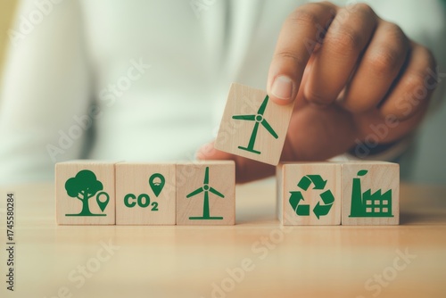 Eco-Friendly Building Blocks: A hand strategically places a green energy symbol into a collection of wooden blocks, each representing an aspect of eco-friendliness.