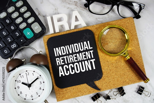 Foto IRA - Individual Retirement Account acronym with calculator, alarm clock and mag