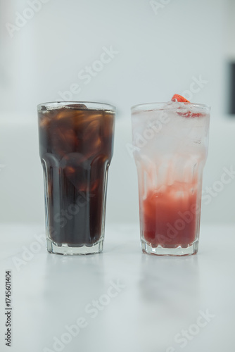 Ice americano black coffee and ice strawberry soda on white table.