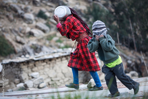 Children from the village of Tupe play and cover their faces, Yauyos, Peru