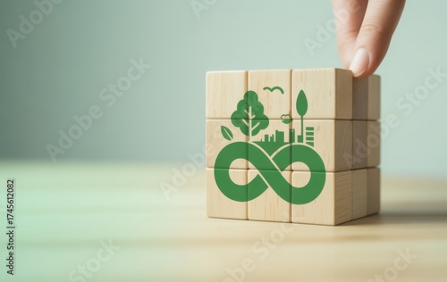 Sustainable future cube : a hand interacts with the sustainable circular cube with eco symbols, representing commitment to sustainable circular economy and nature friendly.