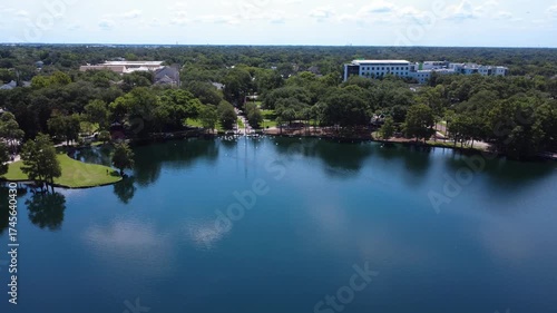 Aerial drone shot zooming into Lake Eola Park in Orlando, Florida — swans and ducks gathering near the waterfront