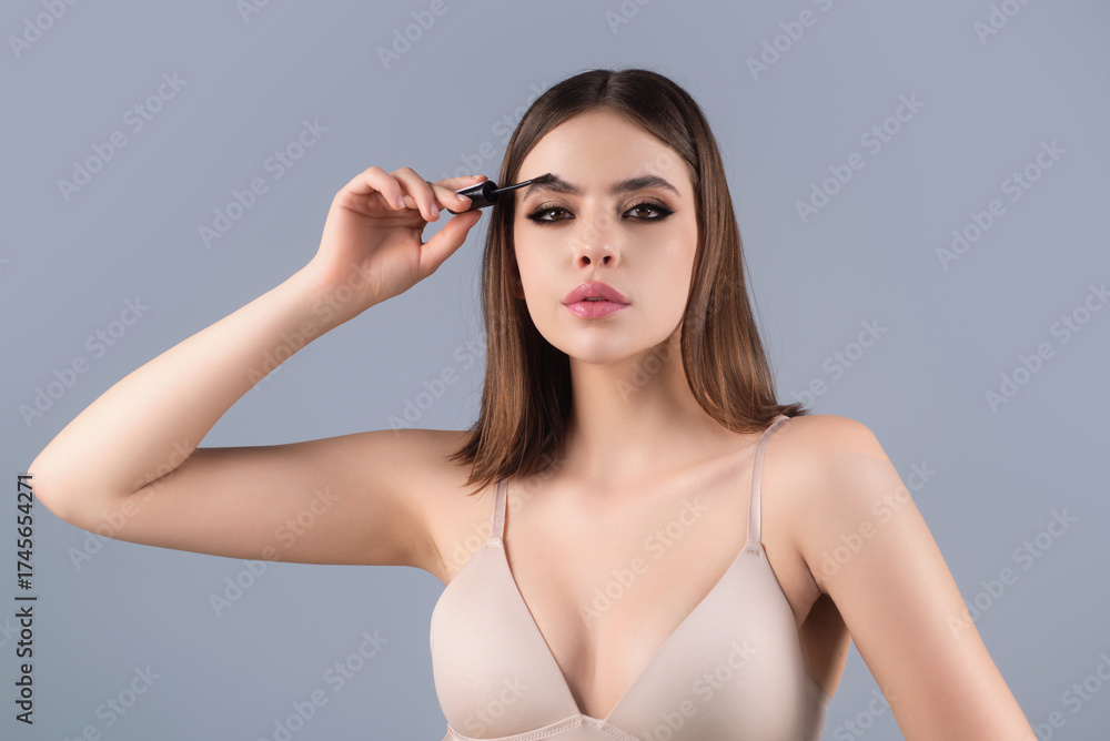 Fototapeta premium Eyebrow makeup. Beauty model shaping brows with brow pencil closeup. Womans eyebrows with eyebrow brush. Natural make up. Modeling brows. Comb eyebrows.