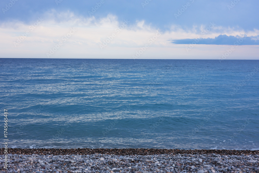 Obraz premium Beautiful view of wavy sea and pebbles on beach