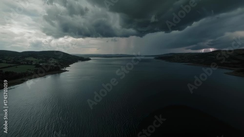 Wallpaper Mural Aerial landscape of a dark lake with green hills under stormy, thunderous clouds with lightning Torontodigital.ca