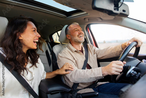 Fotografía Excited woman laughing and joking with her happy husband while driving to vacati