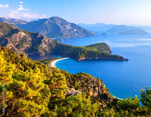 Fototapeta Naklejka Na Ścianę i Meble -  Panoramic coastal view of a bay. Lush greenery meets turquoise water, with mountains in the distance