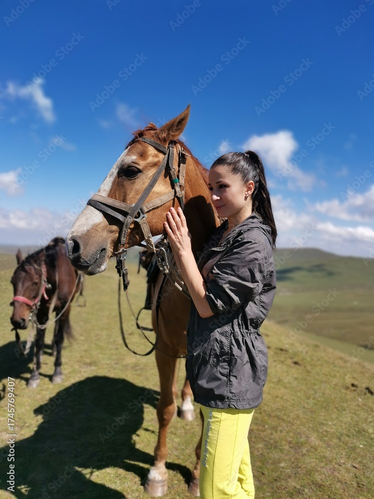 Obraz premium Young caucasian female with horses in scenic mountain landscape