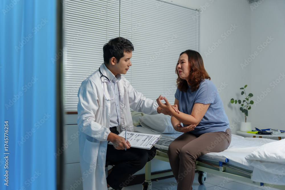 Fototapeta premium Healthcare professional examining woman's painful arm, discussing symptoms during medical consultation in hospital clinic