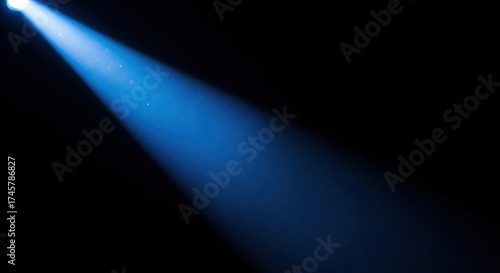 A bright blue spotlight beam shining diagonally against a dark background.