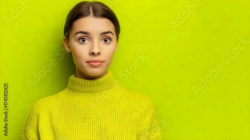 Surprised woman covers mouth in bright green setting