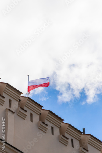Polish flag on building, waving in the wind, white background with copy space