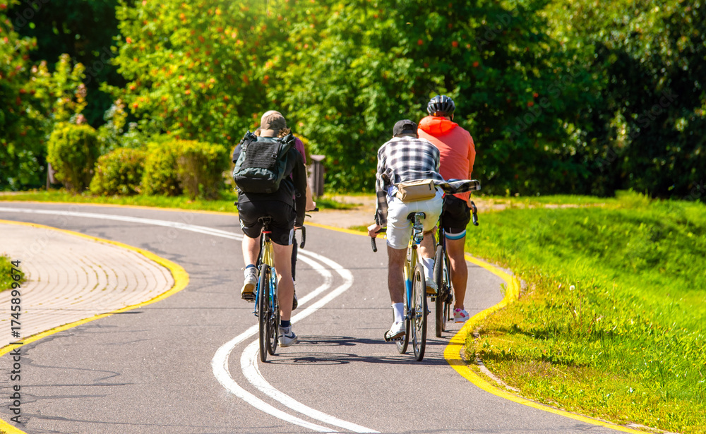 Obraz premium Cyclists ride on the bike path in the city Park 